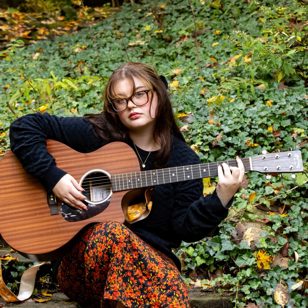 Norah Marie sitting with acoustic guitar