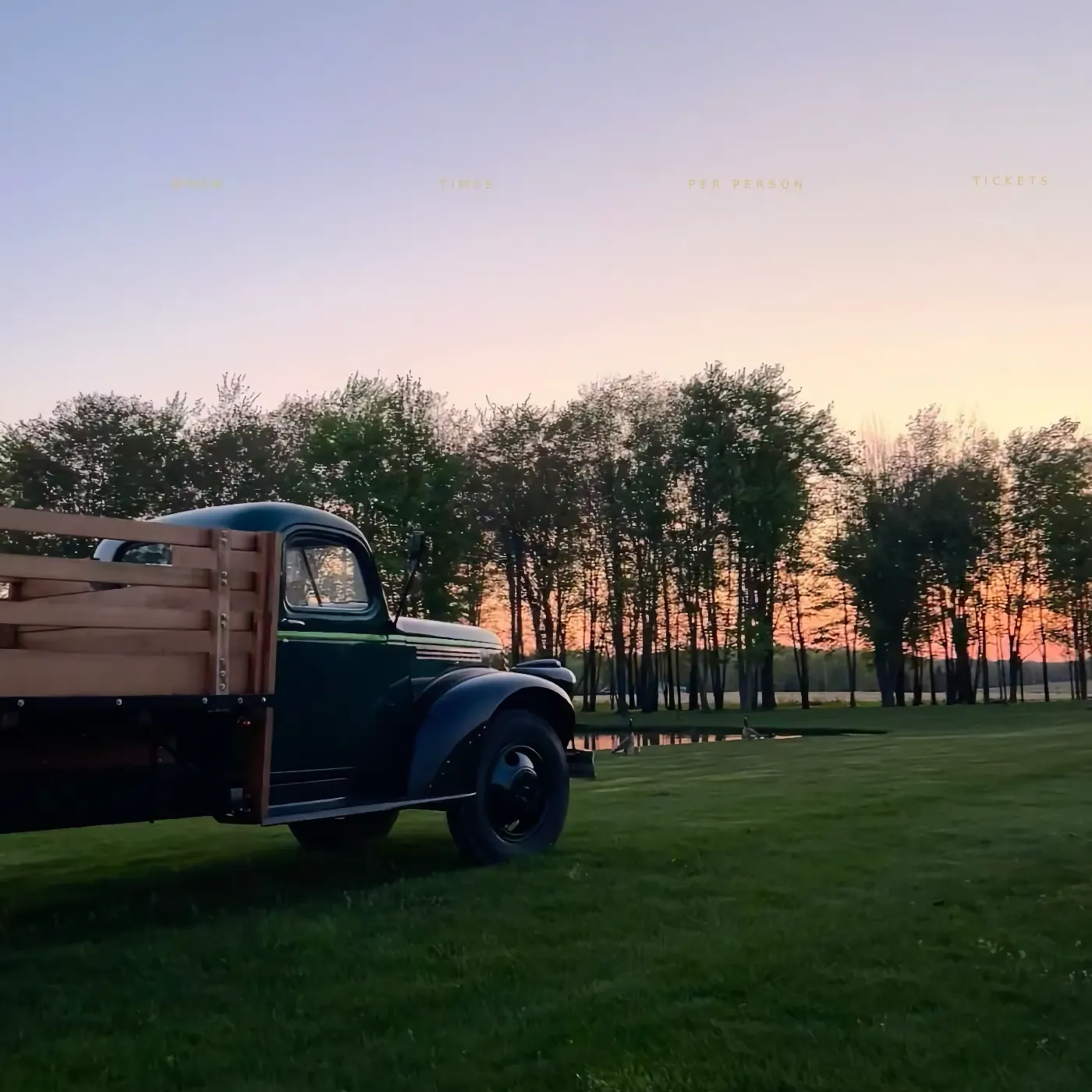 Vintage Laurentia truck on the lawn at sunset, treeline behind