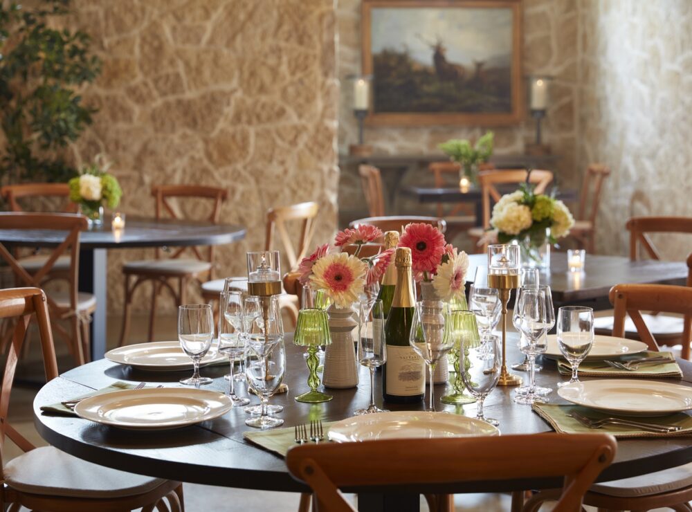 Round table set with sparkling wine and gerbera daisies
