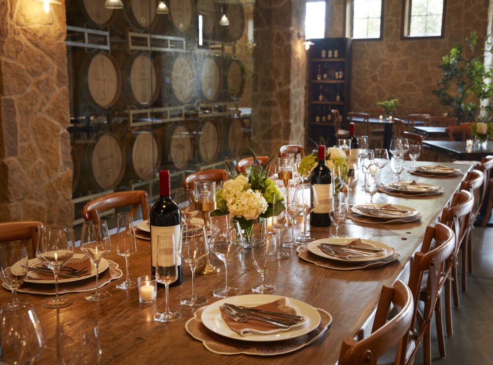 Cellar table set with wine and hydrangeas for a rehearsal dinner
